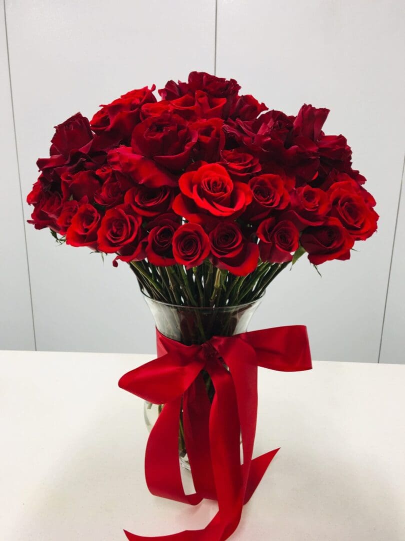 100 red roses in clear vase with red bow valentine's day 